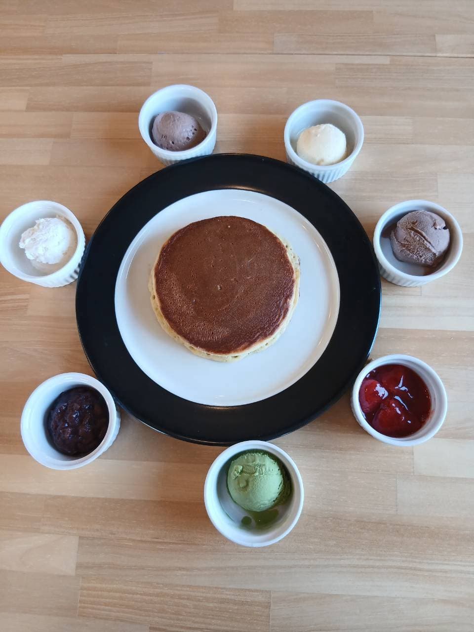 ホットケーキを囲むように並んだトッピングの小鉢