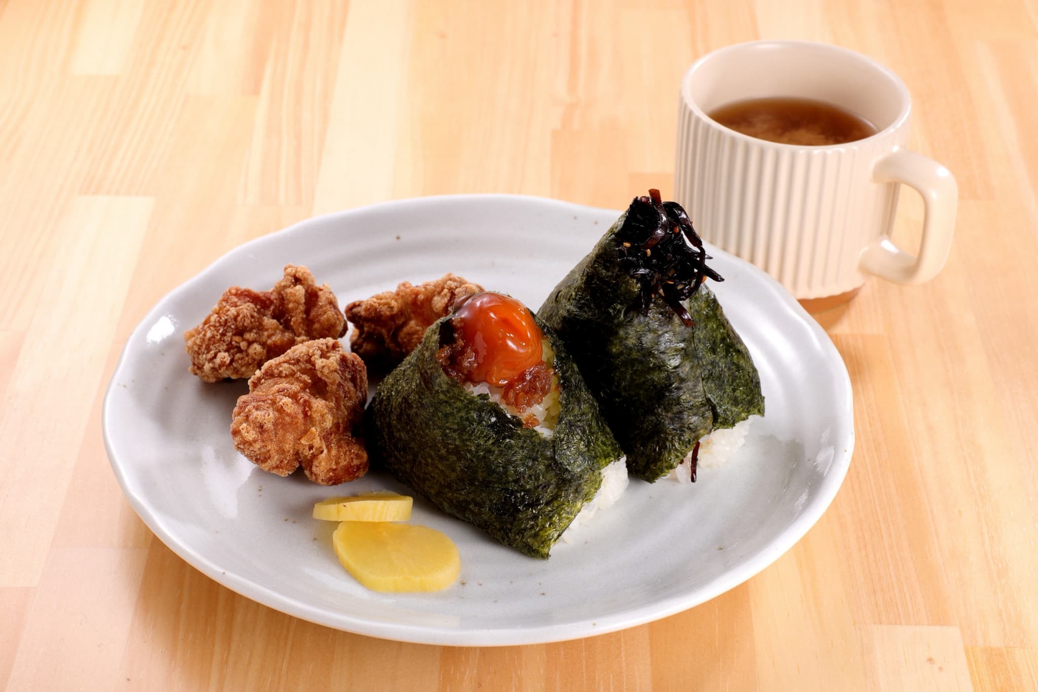 おにぎり2種と唐揚げ、漬物、スープがそろったモーニングプレート